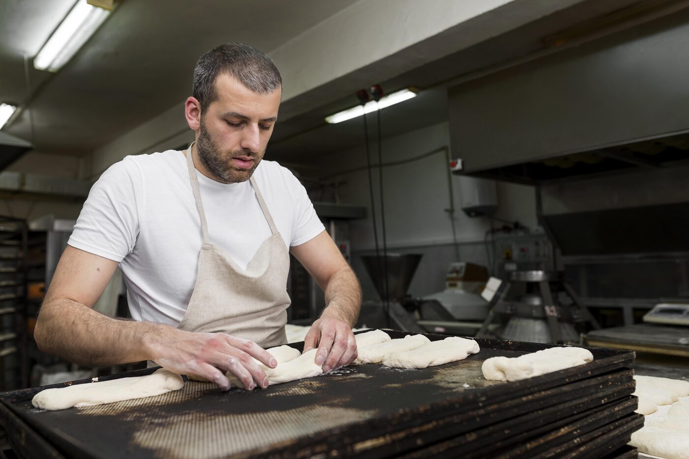 Un boulanger façonne ses pâtons au fournil