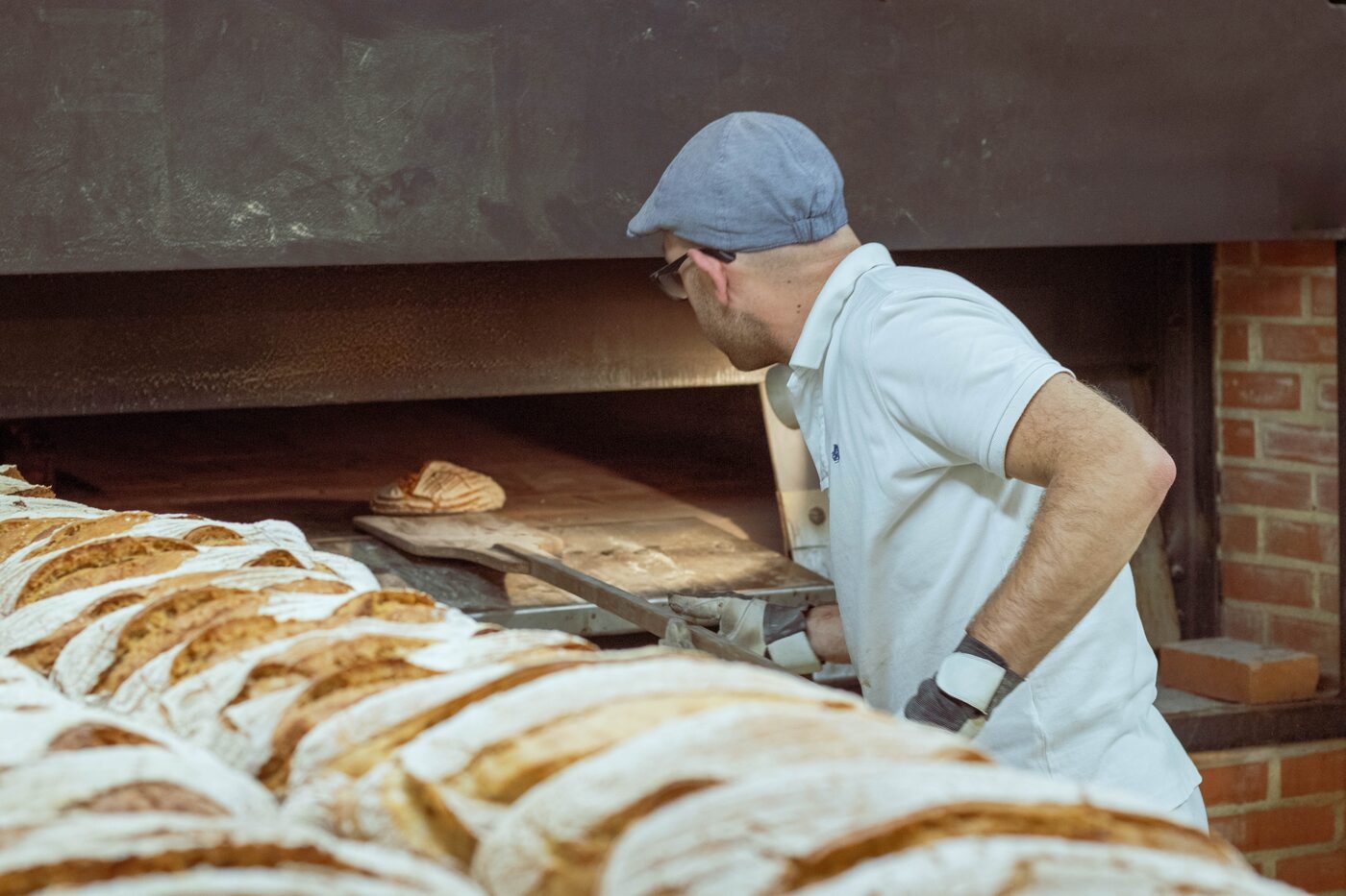Un boulanger enfourne, pelle à la main