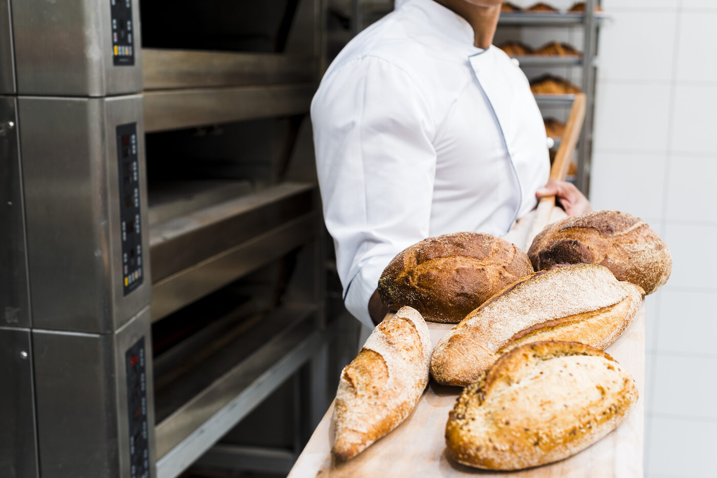 Un boulanger sort les pains du four à la pelle